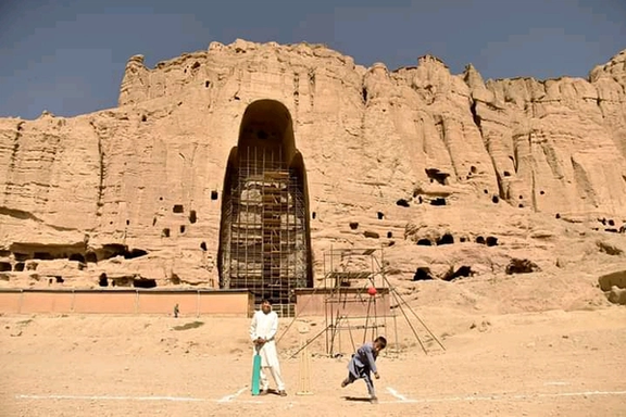 په بامیانو کې د بودا لرغونې مجسمه یو شمېر کوچنیان یې مخې ته په لوبو بوخت دي