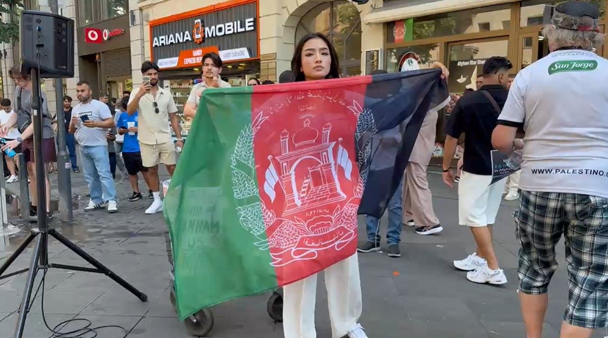 دختری با بیرق ملی در فرانکفورت همزمان با پنجمین سالگرد بازگشت طالبان