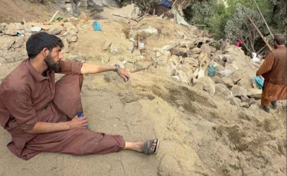 جوانی در کنر پس از ساعت‌ها جست‌وجو در میان ویرانه‌ها، خسته و فرسوده بر زمین نشسته است؛ اندکی مکث در دل خرابه‌هایی که همه زندگی‌اش را بلعیده‌اند.