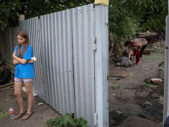 زن اوکراینی در کنار جسد مادرشوهر ۷۵ سالهاش که در حمله روسیه کشته شد -۹ جولای ۲۰۲۲