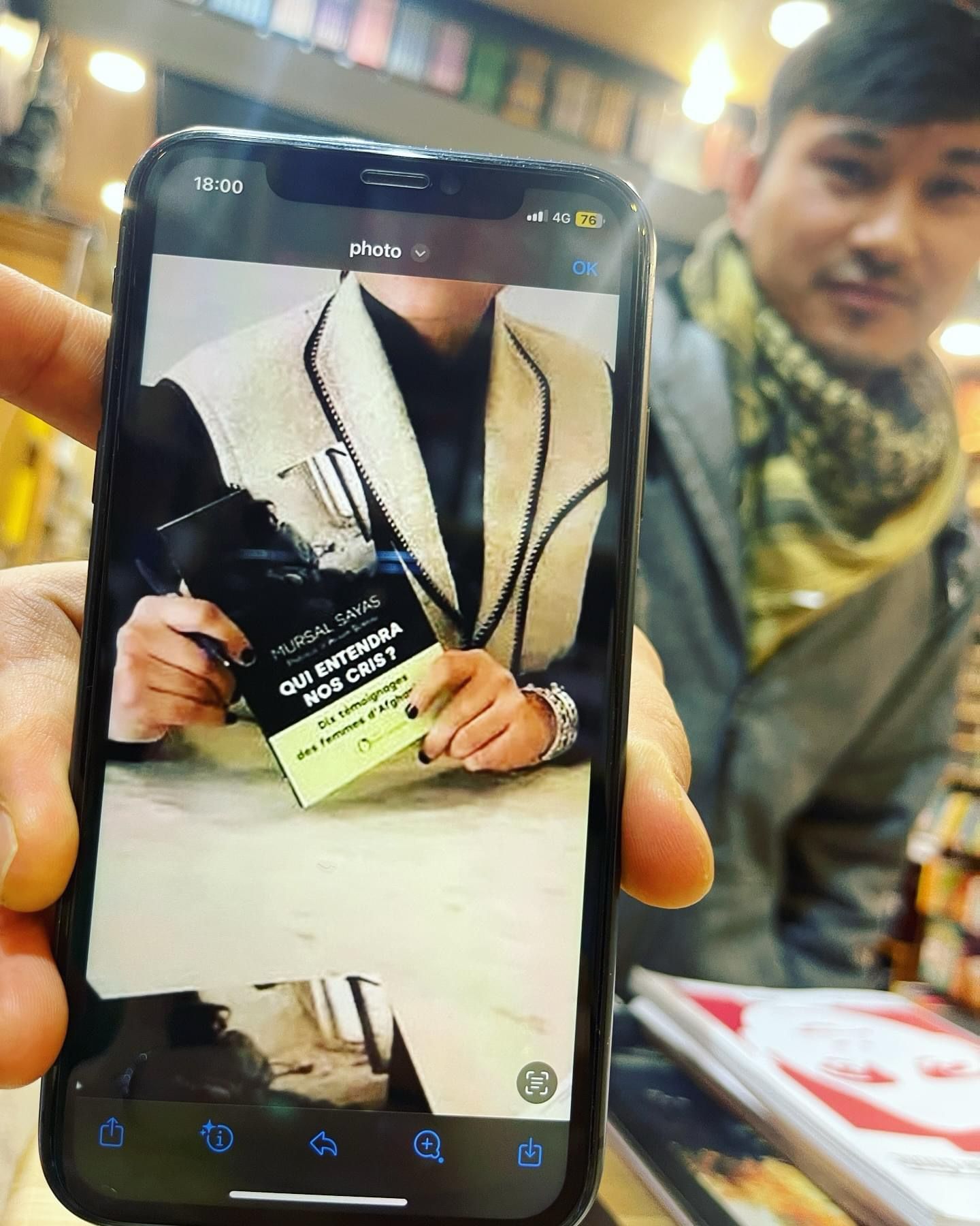 a man is holding a cell phone with a picture of a man on it