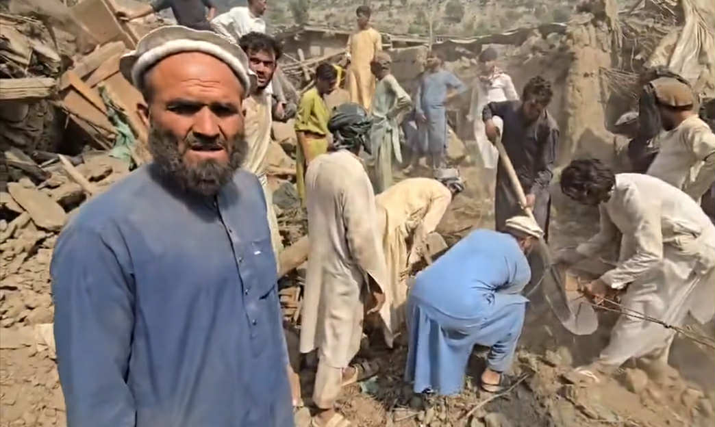 مردم با بیل و کلنگ اجساد قربانیان زلزله را در میان ویرانه‌های کنر دفن می‌کنند.