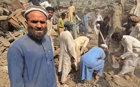 مردم با بیل و کلنگ اجساد قربانیان زلزله را در میان ویرانههای کنر دفن میکنند.